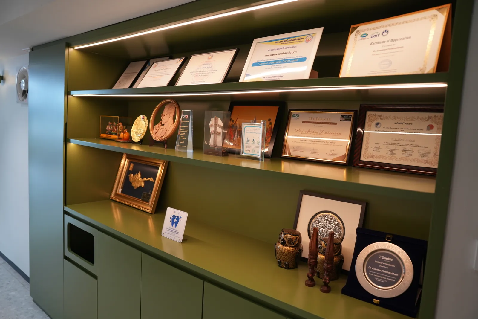 A shelf of awards and certificates earned by the clinical team
